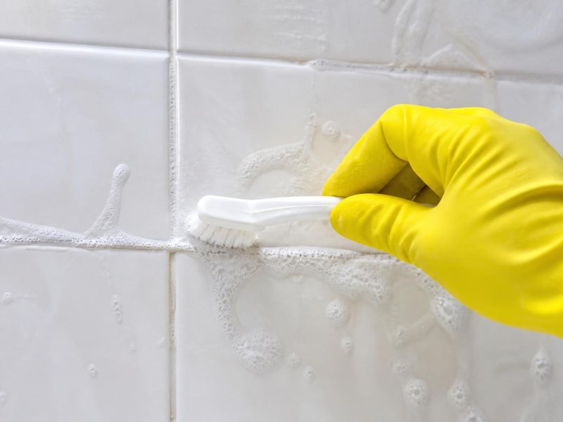 Cleaner scrubbing bathroom grout with a brush