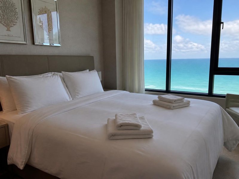 Hotel-style made bed in a vacation rental with folded towels